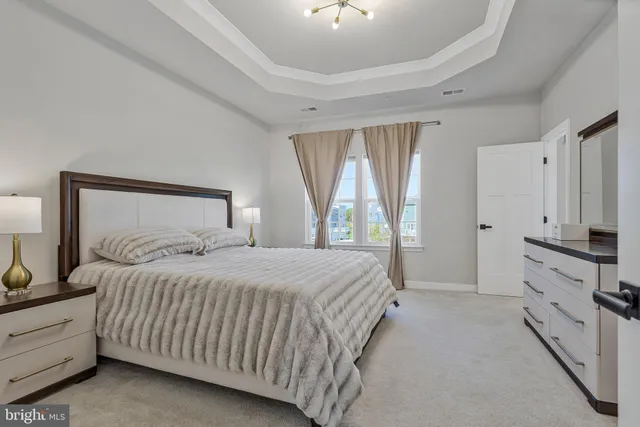 a bedroom with a large bed and a chandelier