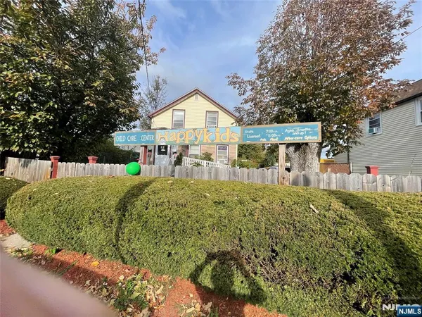 a view of a house with a yard and potted plants