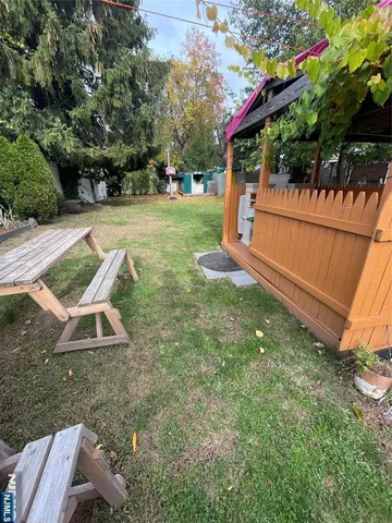 a view of a backyard with wooden fence and a bench