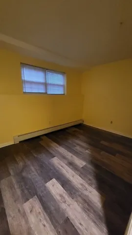 a view of a room with wooden floor and white walls