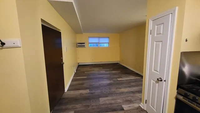 a view of a hallway with wooden floor and closet area