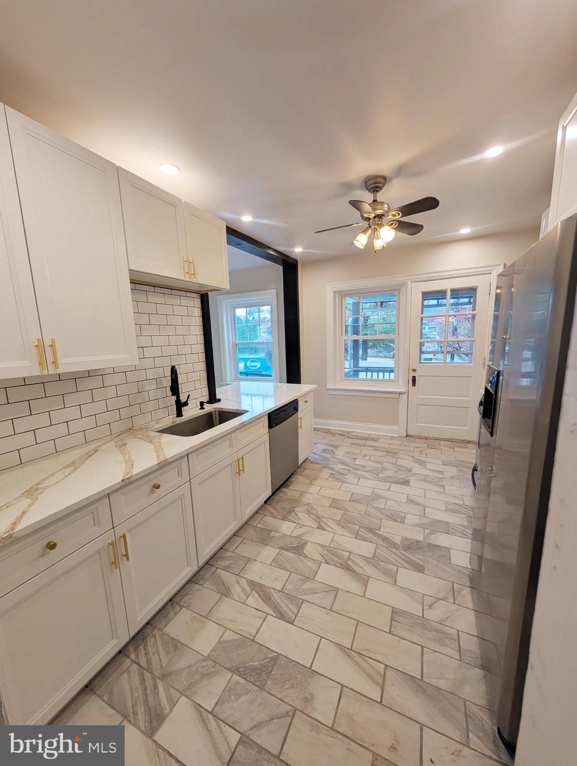 1322 Garfield Avenue Reading, PA 19610 - Photo 2 of 10 a large white kitchen with a sink and dishwasher a stove top oven with wooden floor
