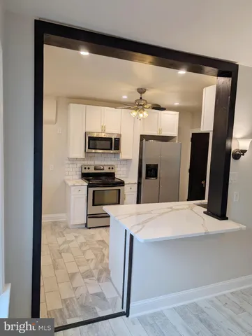 a kitchen with stainless steel appliances kitchen island granite countertop a refrigerator and a stove