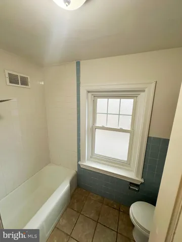a bathroom with a bathtub and window