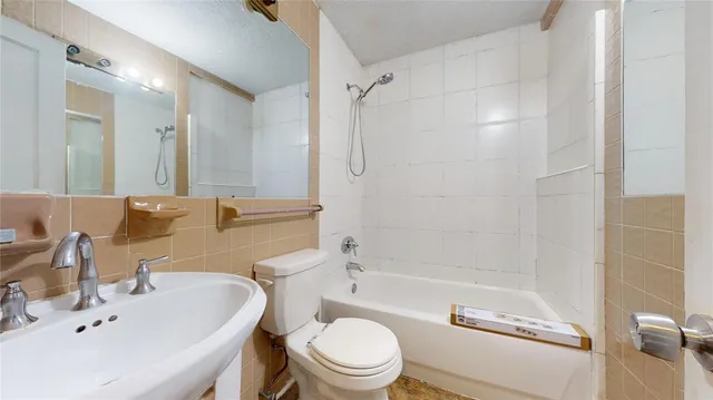 a bathroom with a bathtub shower sink mirror vanity and toilet