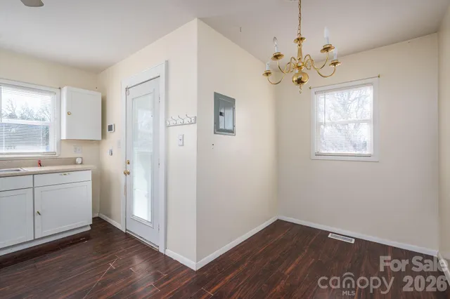 a view of a kitchen with wooden floor and a window