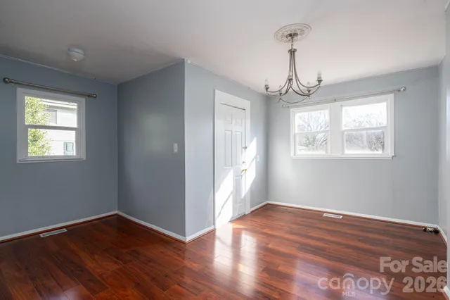 a view of empty room with wooden floor and window