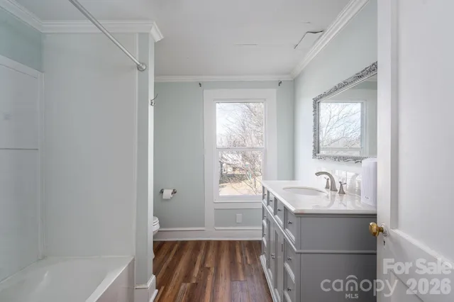 a bathroom with a sink a bathtub and a window
