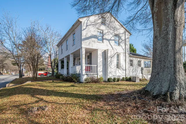 a view of a house with a large tree in front of it