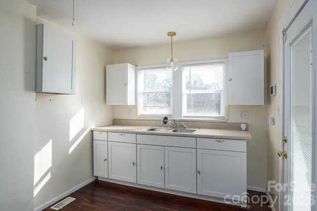 a kitchen with a sink window and cabinets