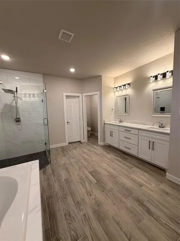 a spacious bathroom with a tub shower and sink