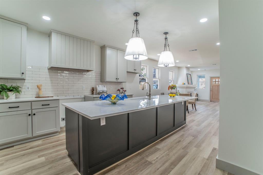 5914 Victor Street Dallas, TX 75214 - Photo 2 of 32 a kitchen with kitchen island granite countertop a sink cabinets and wooden floor