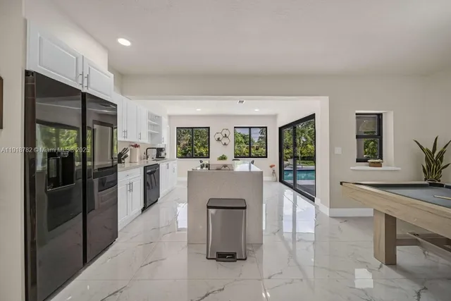 a kitchen with stainless steel appliances granite countertop a refrigerator and a sink