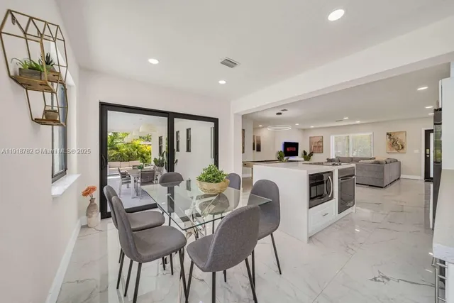 a view of a dining room with furniture and a kitchen