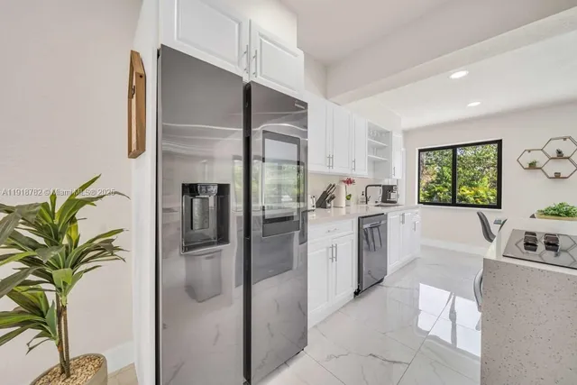 a kitchen with stainless steel appliances a refrigerator a sink a stove top oven a counter space and cabinets