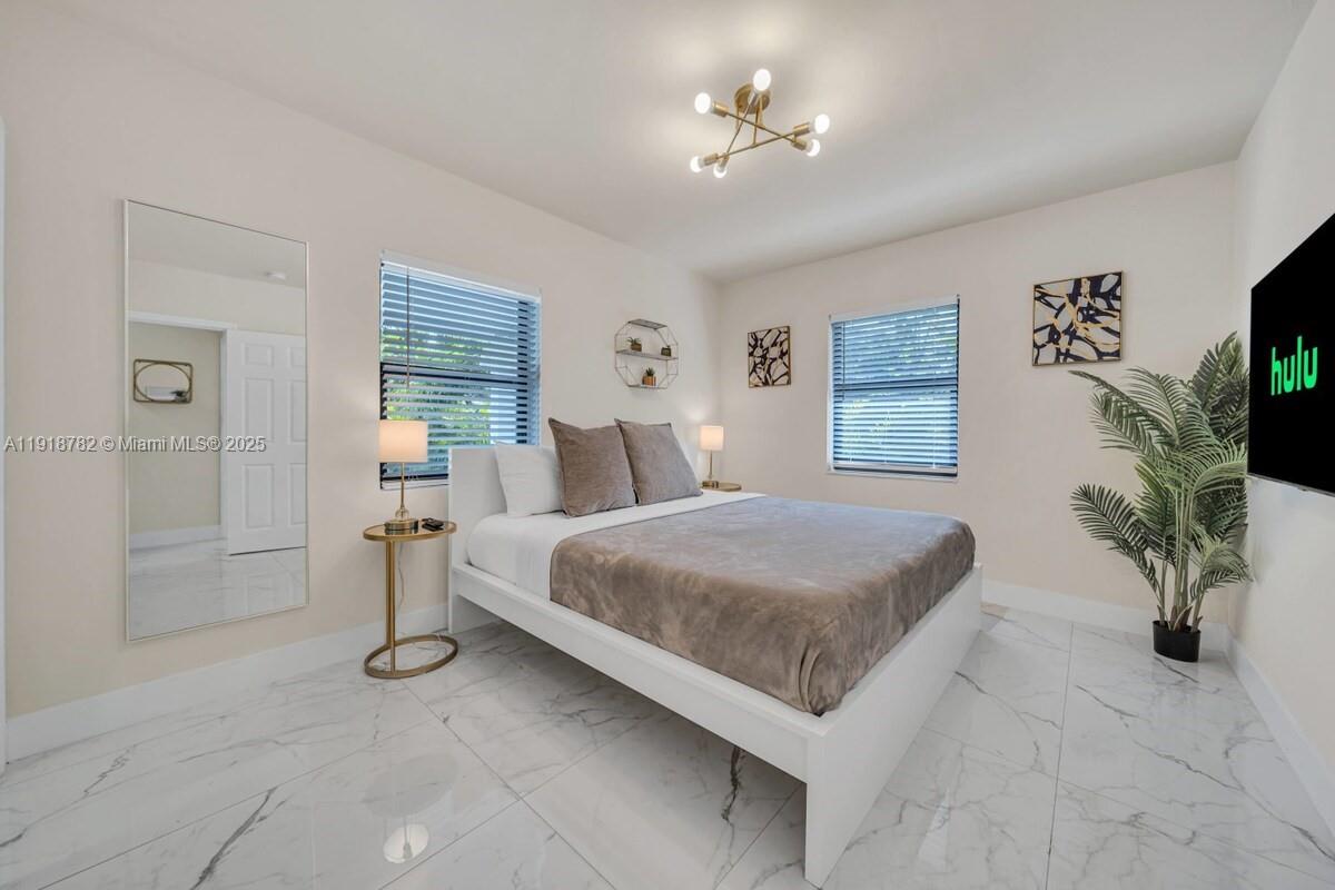 305 Northwest 124th Street North Miami, FL 33168 - Photo 18 of 41 a bed room with a bed and a chandelier