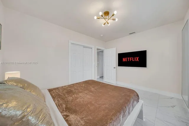 a bedroom with a bed and a chandelier