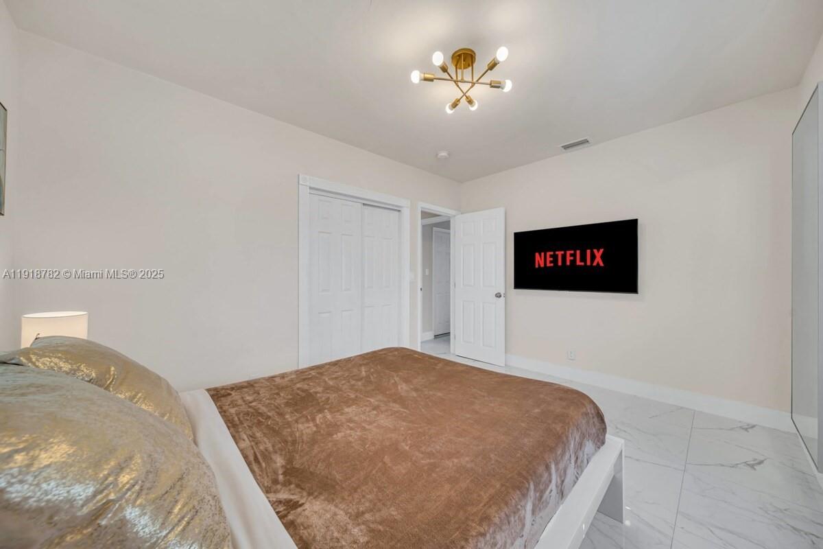 305 Northwest 124th Street North Miami, FL 33168 - Photo 25 of 41 a bedroom with a bed and a chandelier