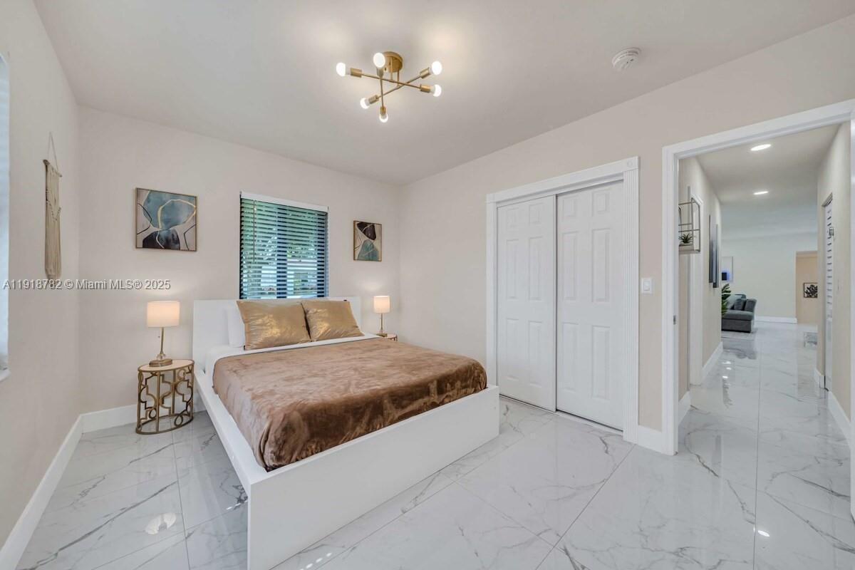 305 Northwest 124th Street North Miami, FL 33168 - Photo 26 of 41 a bedroom with a bed and a chandelier