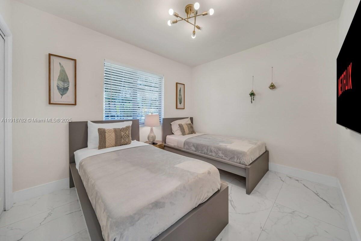 305 Northwest 124th Street North Miami, FL 33168 - Photo 27 of 41 a bedroom with two beds and a flat screen tv