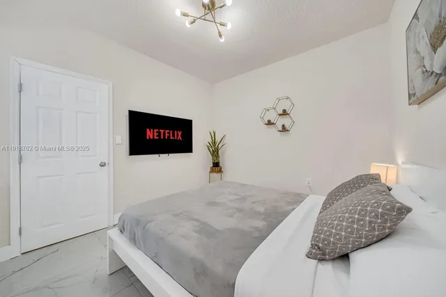 a bedroom with a bed and a painting on the wall