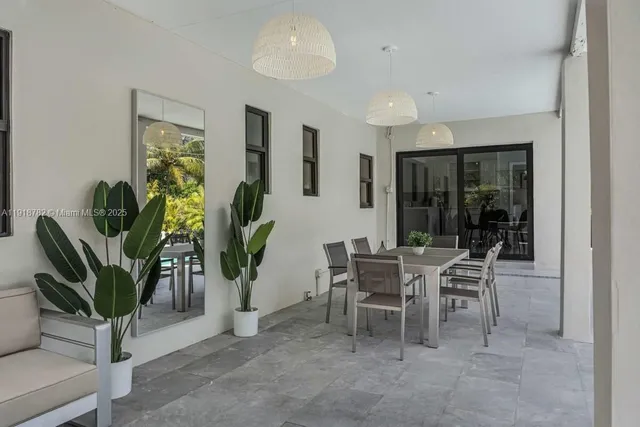 a dining room with furniture and a potted plant