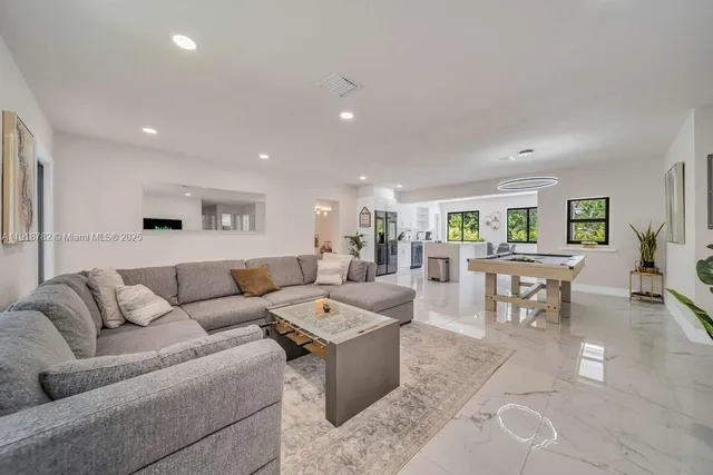 a living room with furniture and view of kitchen