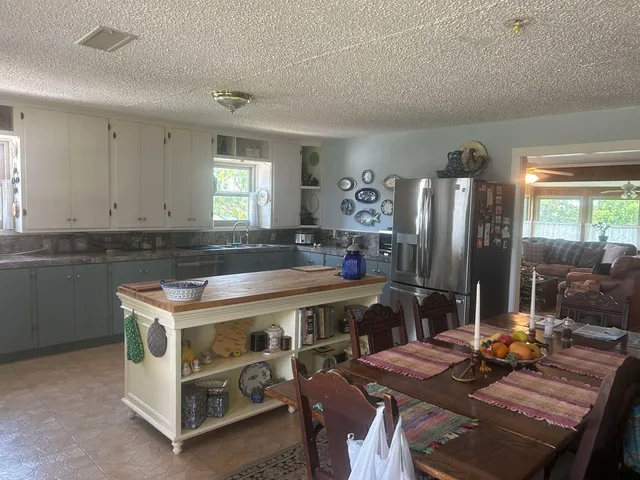 a kitchen with a stove a refrigerator and a dining table