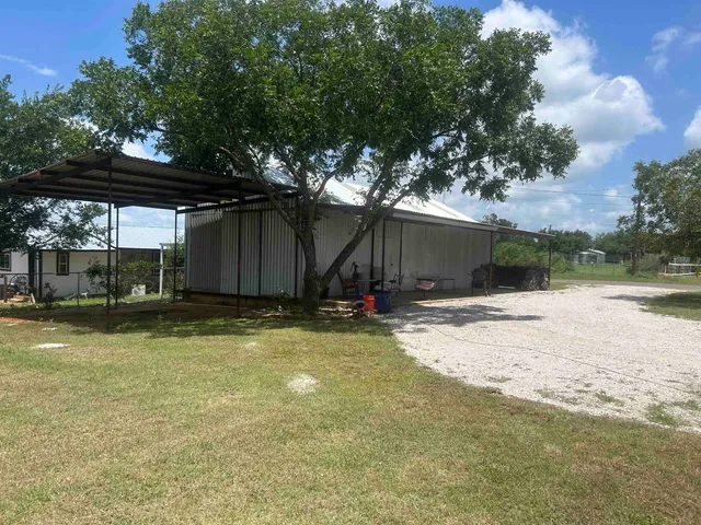 a view of a house with backyard and sitting area