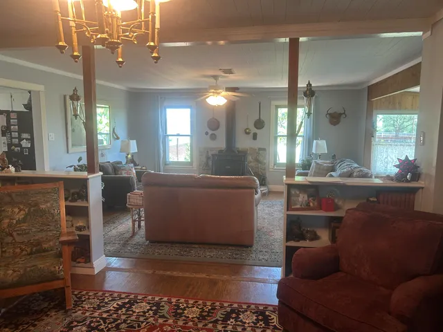 a living room with furniture a chandelier and a dining table