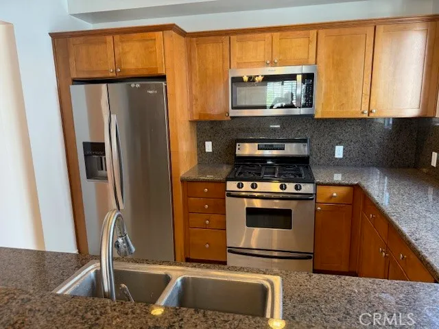 a kitchen with stainless steel appliances granite countertop a stove a microwave and a sink