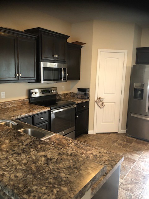 435 Kubota Drive Murfreesboro, TN 37128 - Photo 4 of 8 a kitchen with stainless steel appliances granite countertop a stove a sink and a microwave