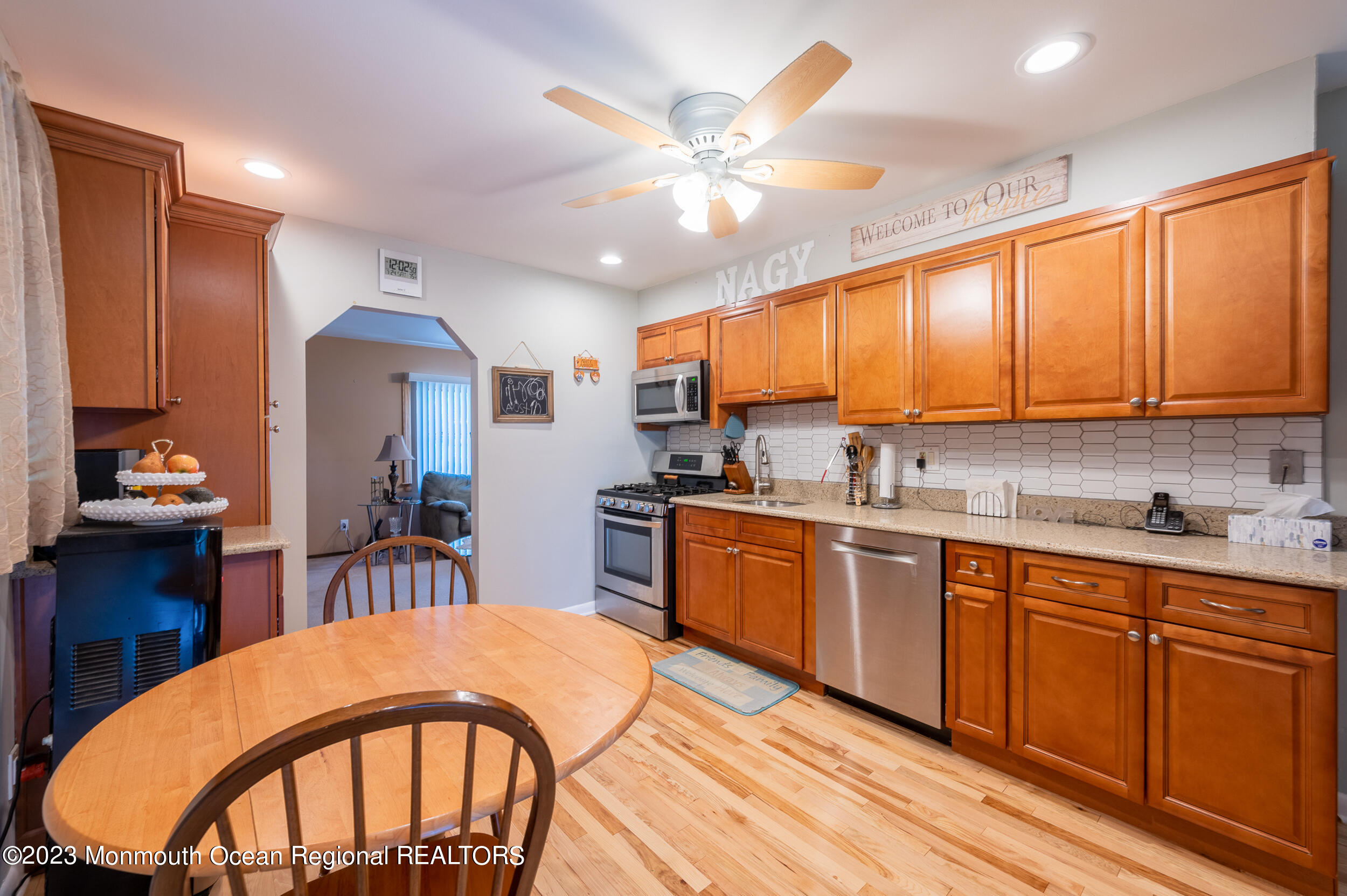 3 Amherst Road Toms River, NJ 08757 - Photo 8 of 19 a kitchen with stainless steel appliances granite countertop a stove top oven a sink a dining table and chairs with wooden floor