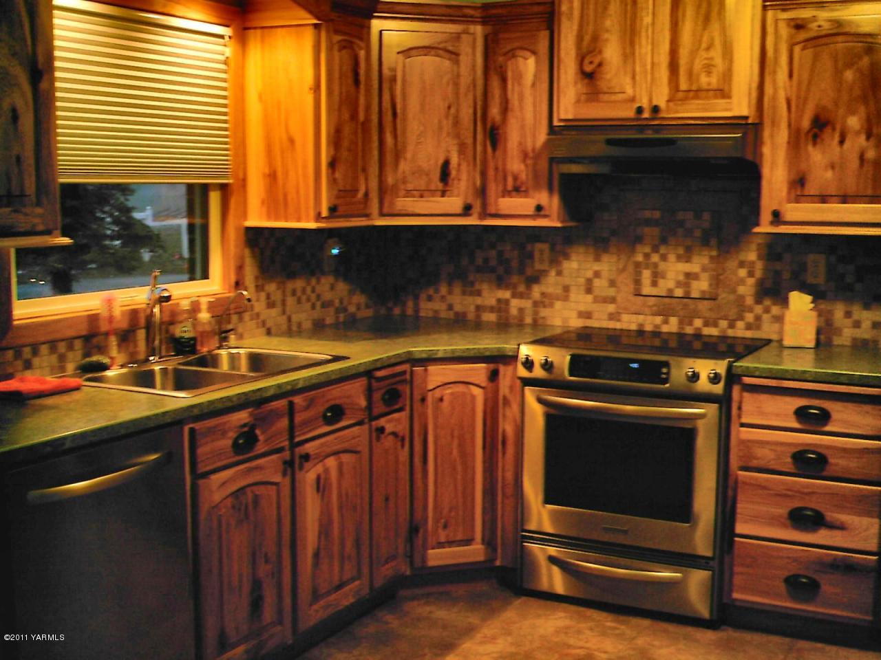 6270 Independence Road Sunnyside, WA 98944 - Photo 2 of 7 a kitchen with granite countertop a stove and a wooden cabinets