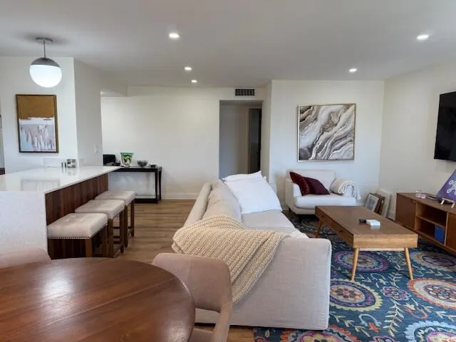 a living room with furniture and wooden floor