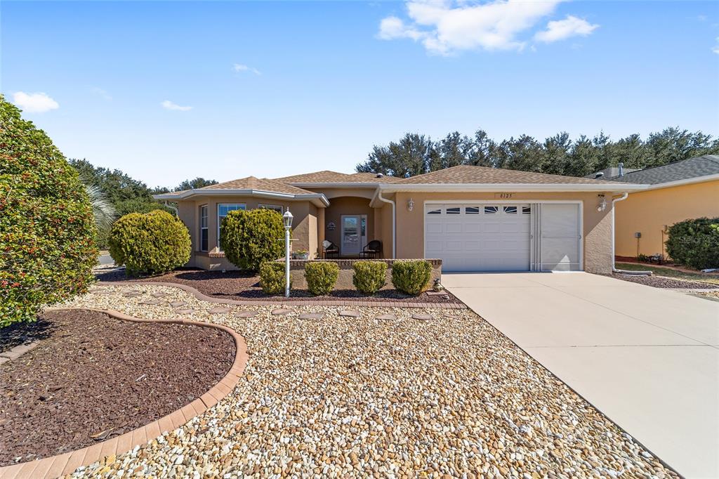 8125 South W 81st Loop Ocala, FL 34476 - Photo 3 of 58 a front view of a house with a yard and trees