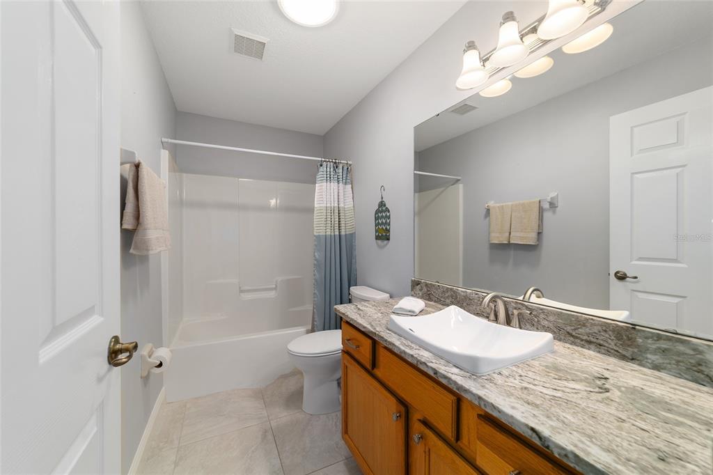 8125 South W 81st Loop Ocala, FL 34476 - Photo 39 of 58 a bathroom with a granite countertop sink a toilet and shower
