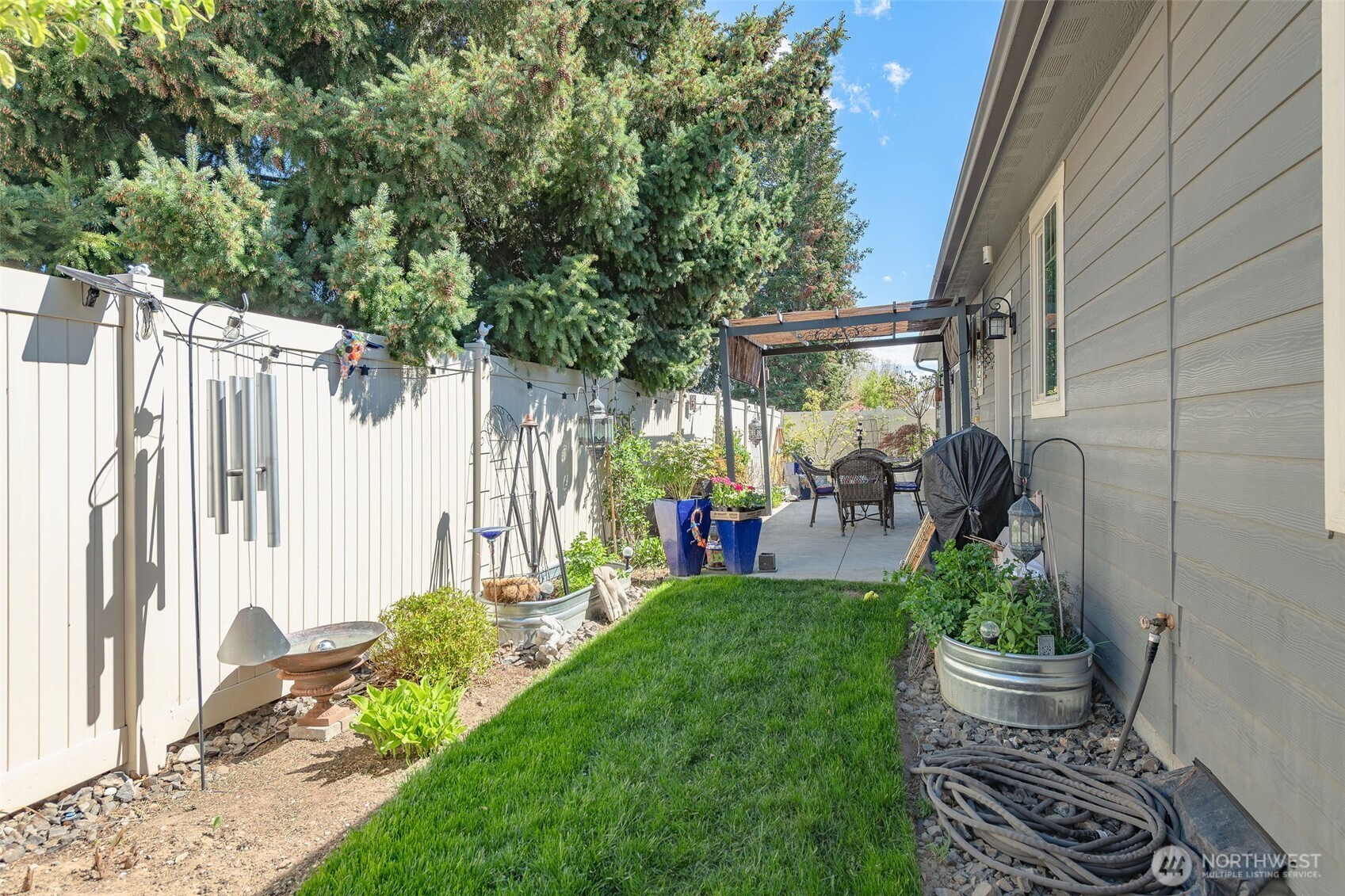 227 Pershing Circle Wenatchee, WA 98801 - Photo 37 of 38 a view of a porch with potted plants and a large tree