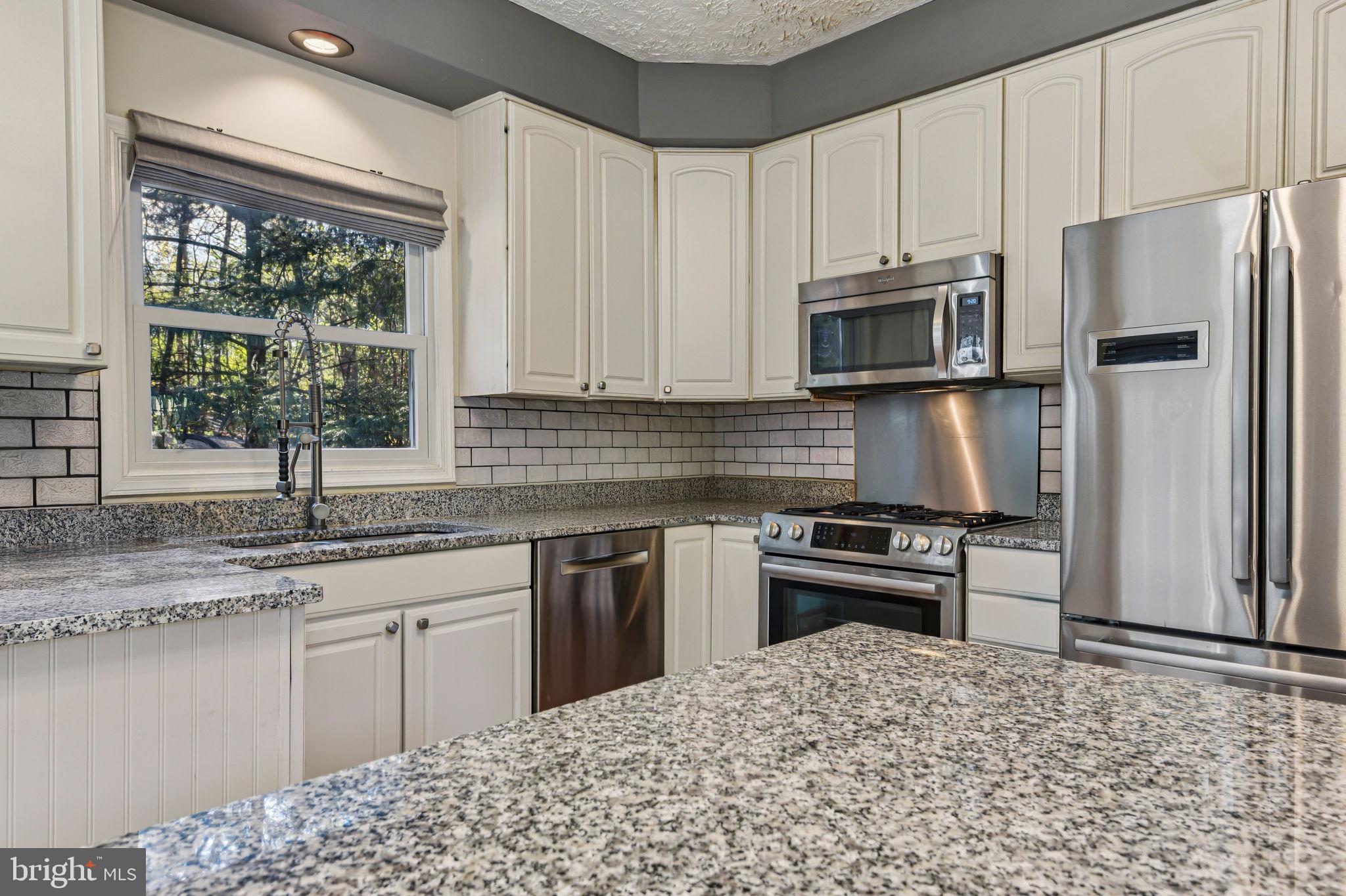 7617 Bear Forest Road Hanover, MD 21076 - Photo 7 of 37 a kitchen with kitchen island granite countertop a stove sink and refrigerator