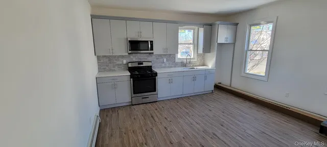 a kitchen with granite countertop a stove top oven and cabinets
