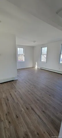 a view of a room with wooden floor