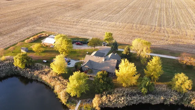 an aerial view of a house with swimming pool and large trees