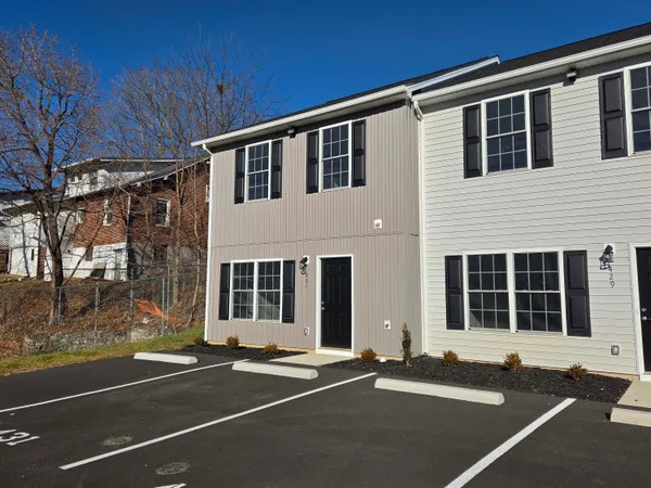 a front view of a house with a parking space