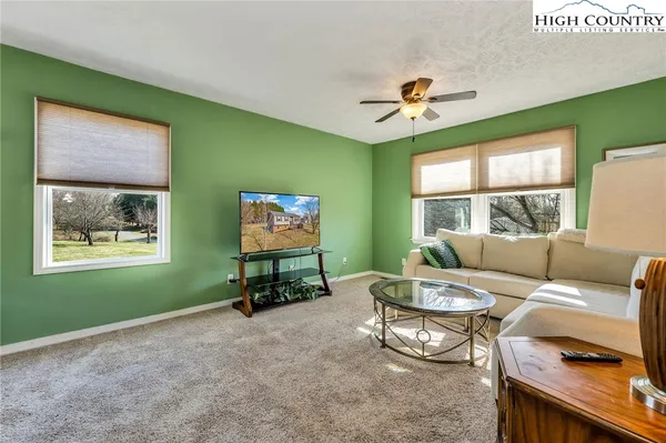 a living room with furniture a window and a flat screen tv