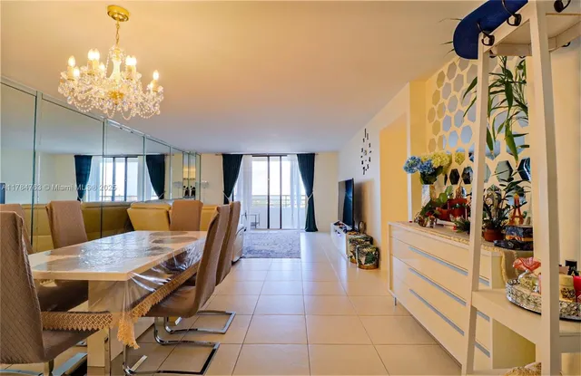 a dining room with wooden floor and chandelier