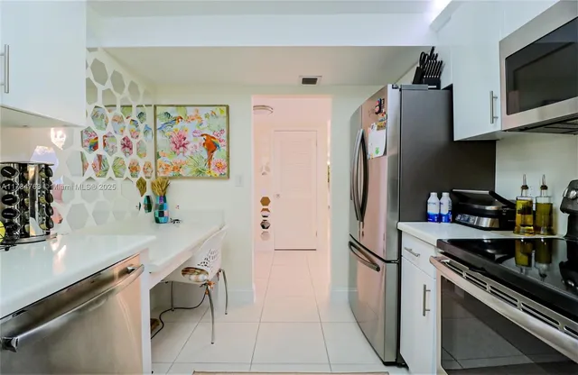 a kitchen with stainless steel appliances a refrigerator and a stove top oven