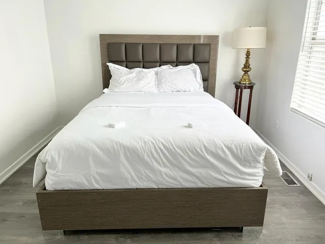 a white bed sitting in a bedroom next to a window