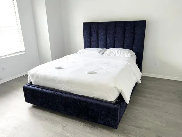 a large bed sitting in a bedroom next to a window