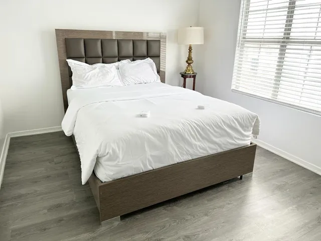 a bed sitting in a bedroom next to a window