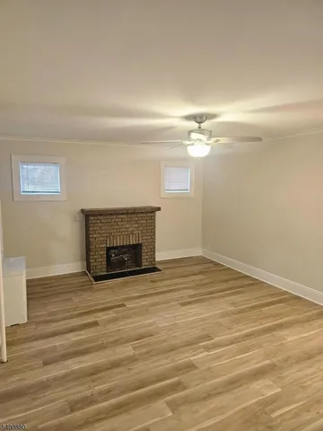 a view of empty room with wooden floor and fireplace
